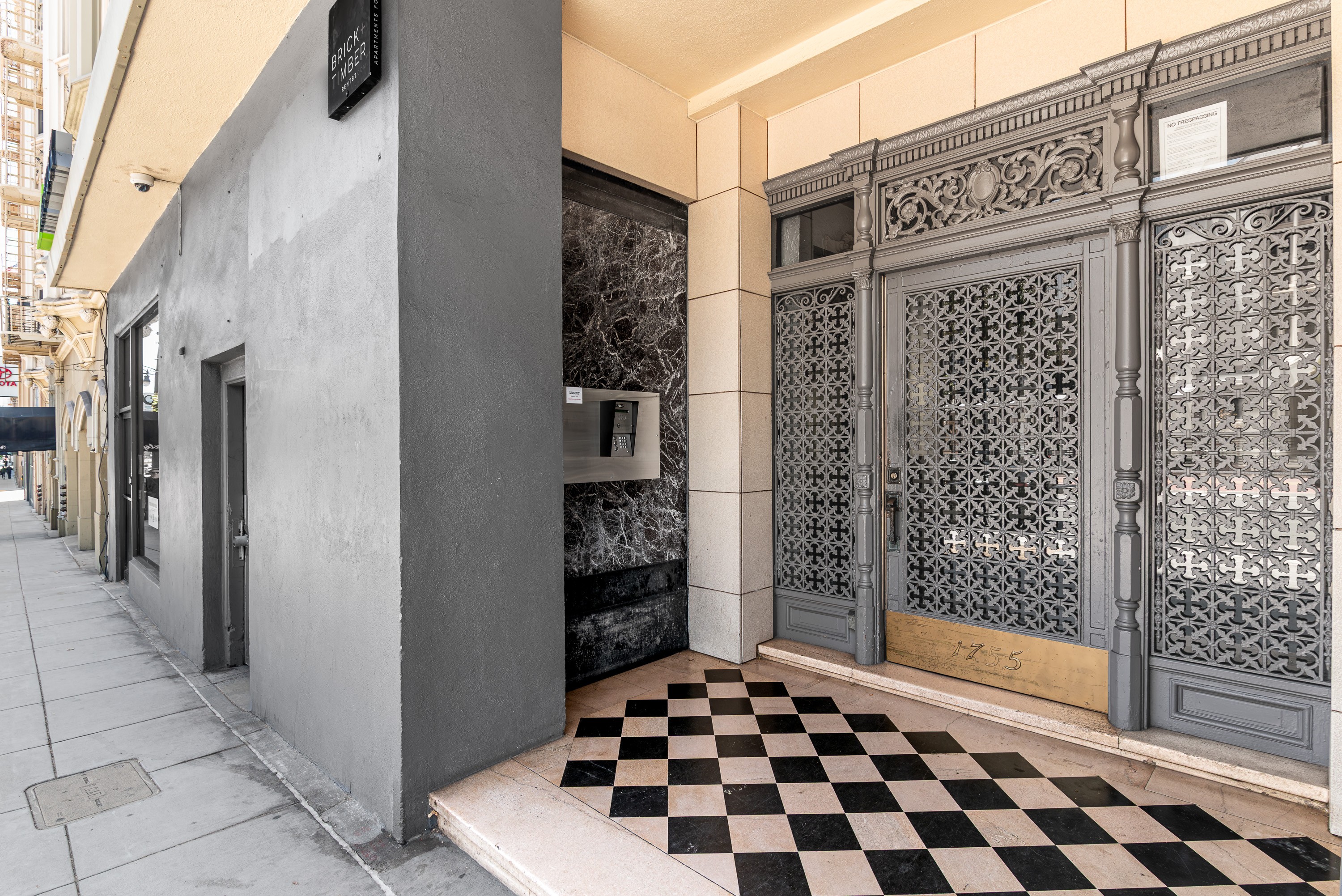 A black and white checkered floor leads to a set of ornate doors.